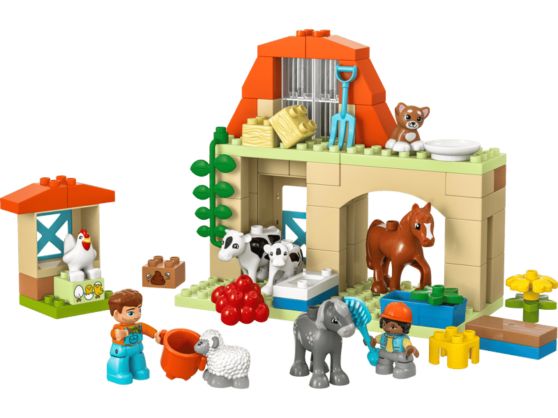 Toddler child hand independently attaching an oversized DUPLO block to the stable roof facade
