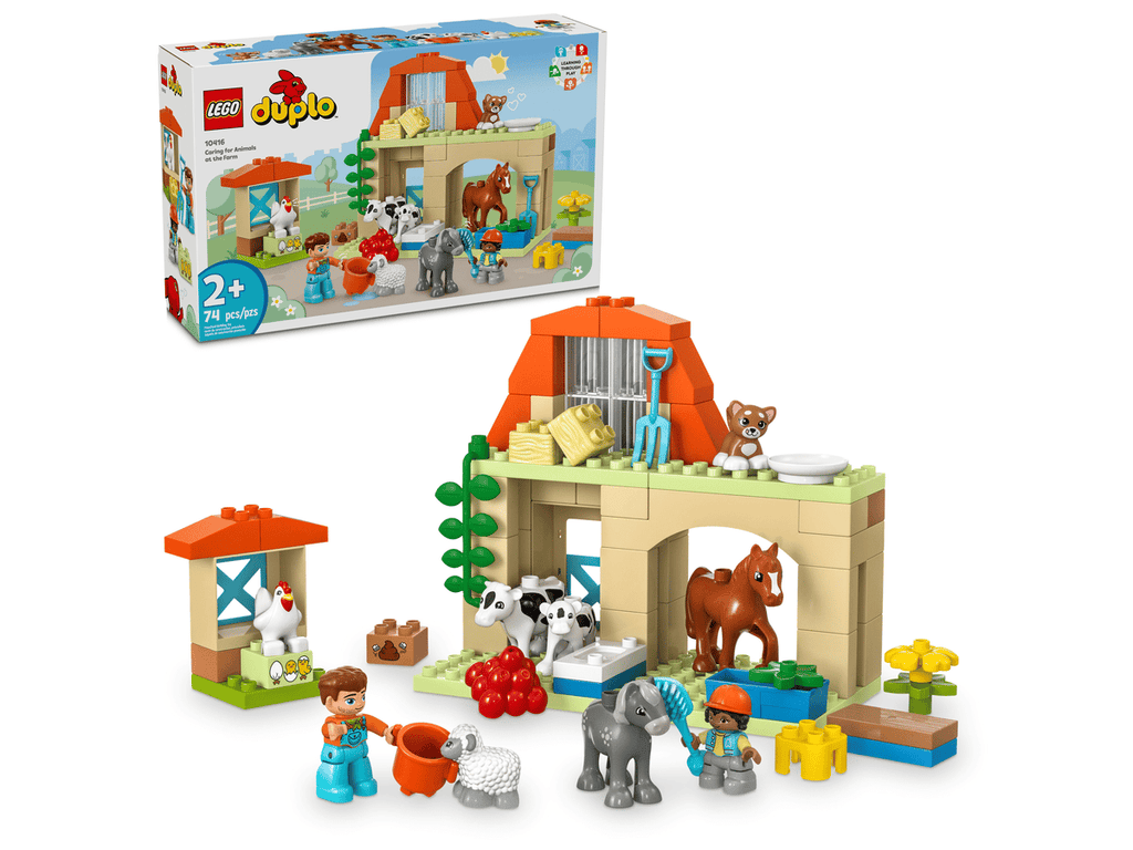 Close up of the 8 included LEGO DUPLO animal figures standing outside the farmhouse gate doors