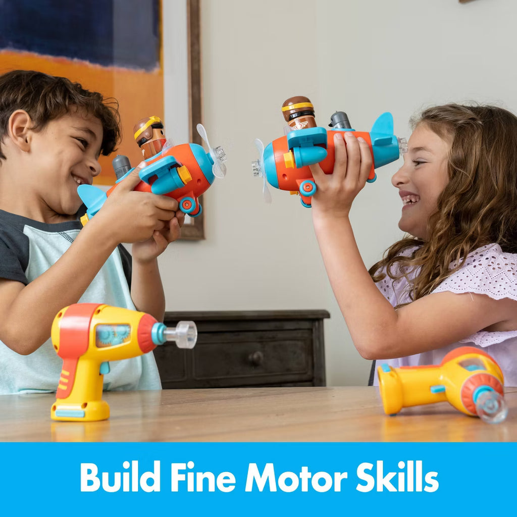 Preschool child using the motorized toy drill to fasten green bolts on the Bolt Buddies airplane