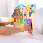 Preschool child hand flipping a bungee hinged wooden block to reveal a gold star icon on the chart
